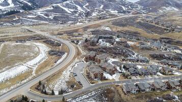 A residential area with a winding road, houses, and a mountainous backdrop.