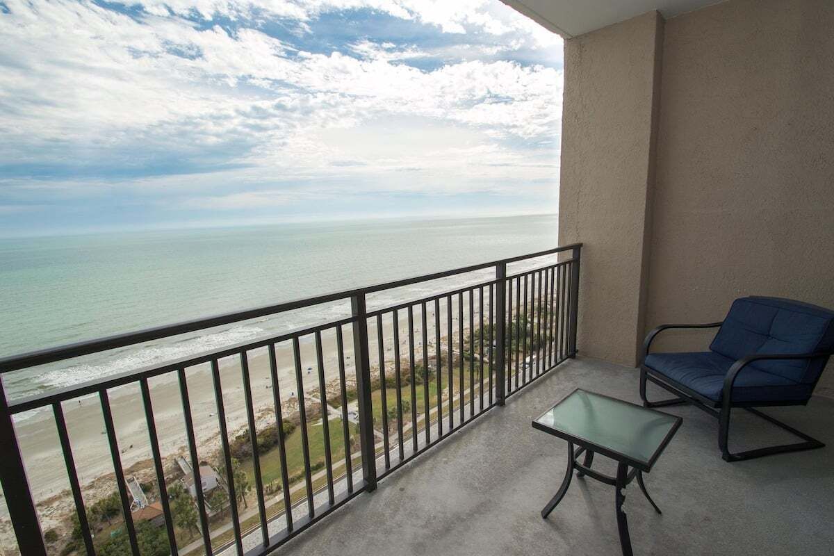 Ein Balkon mit Meerblick, einem Stuhl und einem kleinen Tisch.