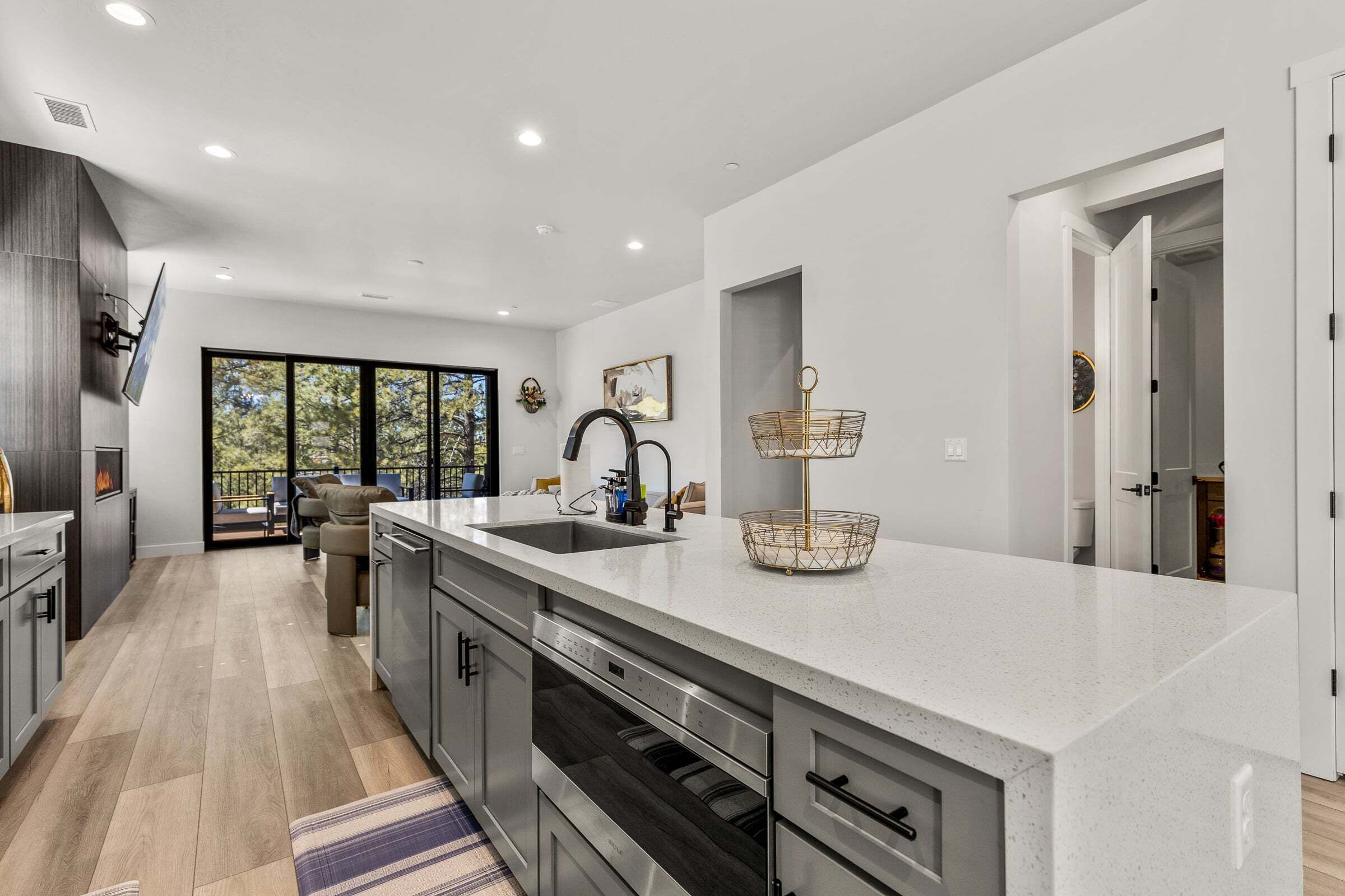 A modern kitchen with a large island, built-in appliances, and a view to the outdoors.
