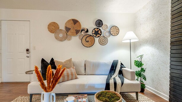 A living room with a sofa, coffee table, decorative wall art, and a lamp. - Nashville - 1808 State St #208 (Nashville)