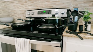 A kitchen with a stove, pots, pans, and utensils. - Kingbed, Resort Style Pool, Gym, Neartheheights (Houston)