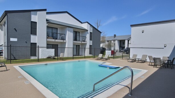 A rectangular swimming pool with a metal ladder, surrounded by a concrete deck and a fence. - Kingbed,a+location,a+for Workers, Longstaydiscount (Sherman)
