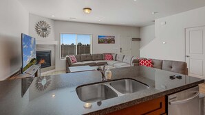 A modern kitchen with a granite countertop, stainless steel sink, and a built-in dishwasher. - Bliss Flagstaff 49 (Flagstaff)
