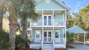 A two-story house with a balcony, a porch, and a small covered area. - Little Wing (Santa Rosa Beach)