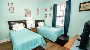 A room with two beds, a desk, a television, and artwork on the walls. - Magnolia Place 4789-103 (Myrtle Beach)
