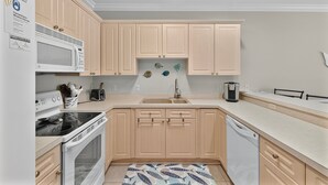Une cuisine moderne avec des meubles en bois, un four à micro-ondes, une cuisinière et un lave-vaisselle.