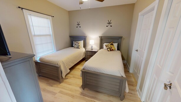 A bedroom with two beds, a nightstand with a lamp, and a dresser. - Magnolia North 4839-204 (Myrtle Beach)