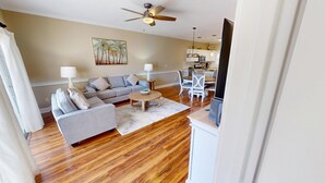 A living room with a sofa set, a coffee table, and a dining area with a table and chairs. - Magnolia North 4839-204 (Myrtle Beach)