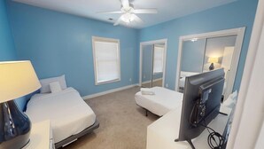 A bedroom with two beds, a ceiling fan, a desk with a computer, and a mirror. - Magnolia Pointe 4869-201 (Myrtle Beach)