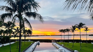 A marina with boats docked, a waterway, and palm trees. - Waterfront Luxury Villa With Sunset Views and Boat Slip (Marathon)