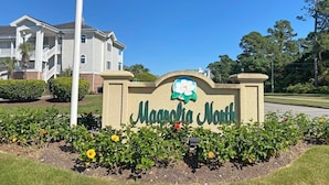 Señal de Magnolia North, con un edificio blanco al fondo.