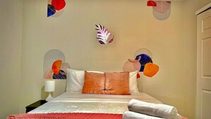 A neatly made bed with a red blanket, white pillows, and a decorative feather on the wall. - Modern&beautiful,pool,a+ Location,longstaydiscount (Sherman)