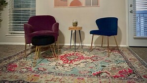 A living room with a patterned rug, a purple armchair, a blue chair, and a small table with a plant. - Modern&beautiful,pool,a+ Location,longstaydiscount (Sherman)
