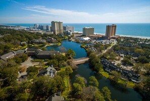 An aerial view of a coastal resort area with multiple high-rise hotels, a marina, and a large body of water. - Windsor Court 11C (Myrtle Beach)