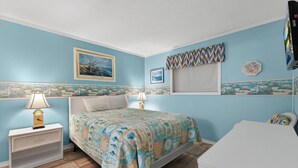 A bedroom with a bed, nightstands, a TV, and wall art. - Myrtle Beach Resort A 210 (Myrtle Beach)