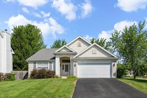 A single-story house with a garage, a front porch, and a well-maintained lawn.