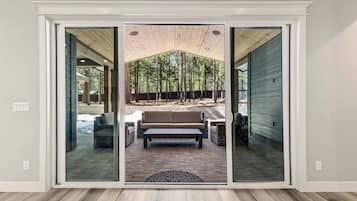 A sliding glass door leading to an outdoor patio with a bench and a table.
