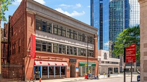 Un bâtiment historique abritant un restaurant Subway au rez-de-chaussée, un panneau indiquant un parking et un panneau annonçant le « Symphony Country Music Hall of Fame ».