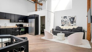 Un appartement moderne doté d’une cuisine, d’un espace de vie et d’une grande fenêtre.