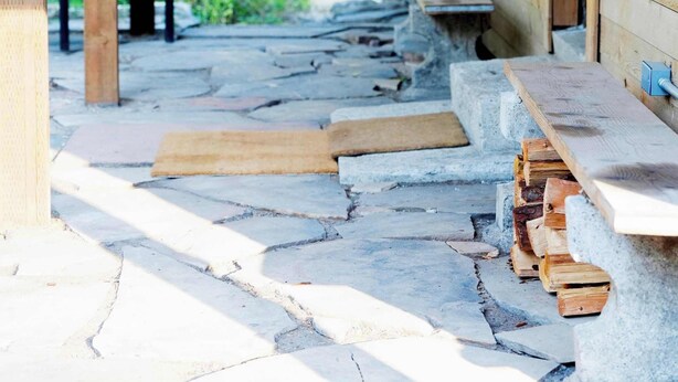 A wooden cabin with a stone-paved porch, a bench, and a chair. - Cozy Cabin Retreat in Midway (Midway)