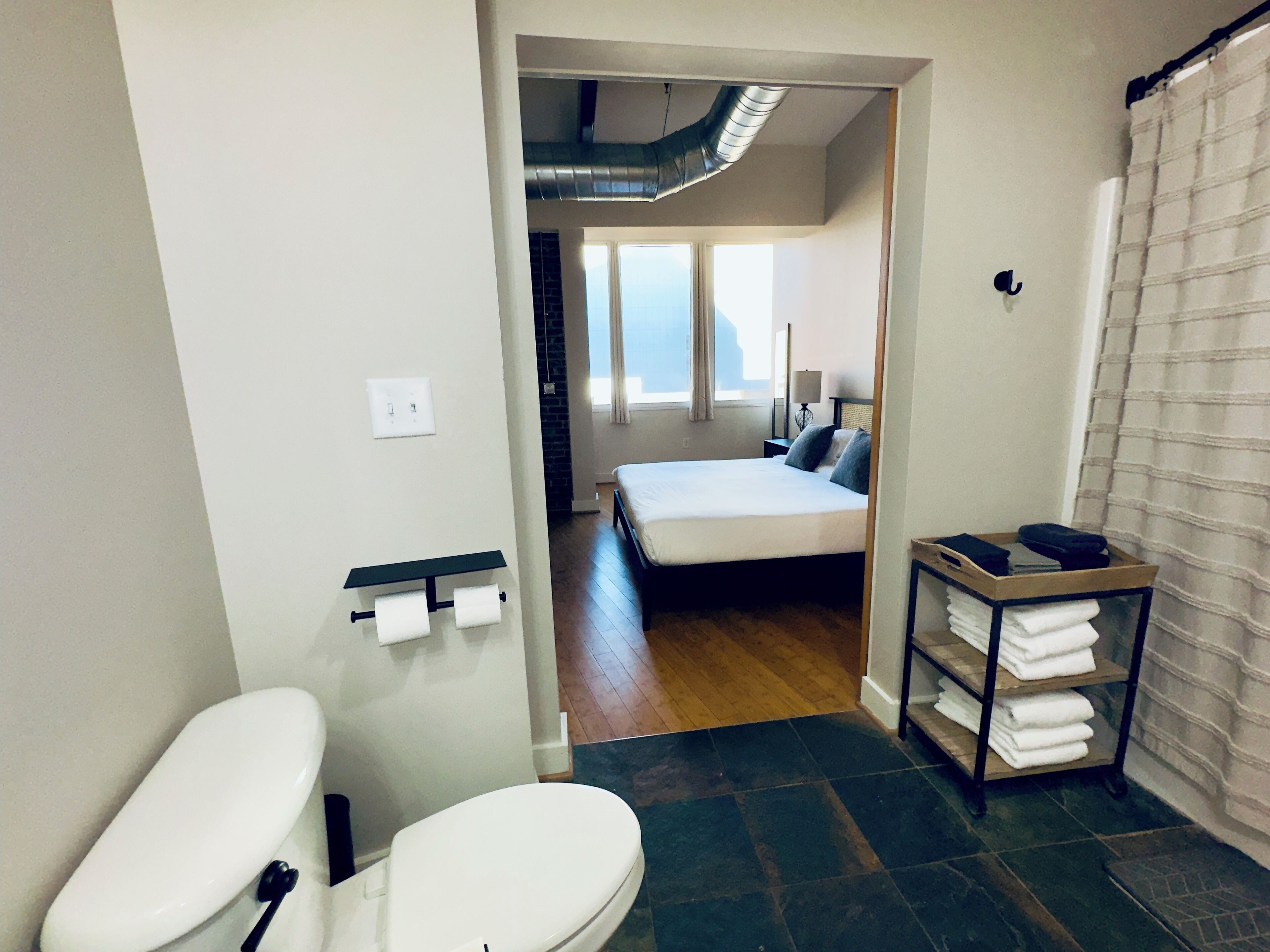 A modern bathroom with a toilet, a sink, and a shower.