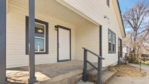 A house with a covered porch, a front door, and a small front yard. - Stylish 1-bedroom Retreat in Fort Worth (Fort Worth)
