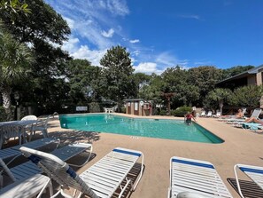 Ein Schwimmbecken mit Liegestühlen und einem Rettungsschwimmerstand.