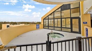 A pool area with a glass enclosure, a lifeguard station, and a sign indicating no lifeguard on duty. - Caravelle 706 (Myrtle Beach)