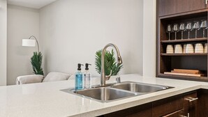 Eine moderne Küche mit einer Spüle aus Edelstahl, einer Arbeitsplatte und Holzschränken.