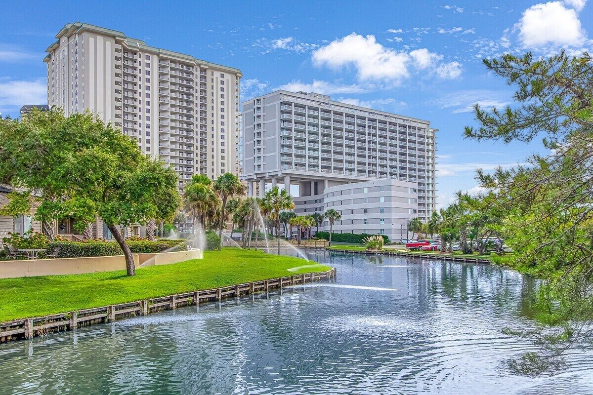 A hotel with a large building and a water feature in front.