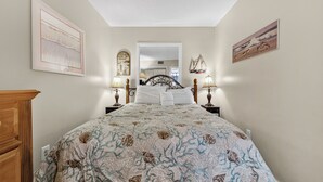 Una camera da letto con un letto, comodini, una cassettiera e decorazioni alle pareti.