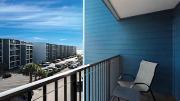 A balcony with a view of a parking lot and buildings.