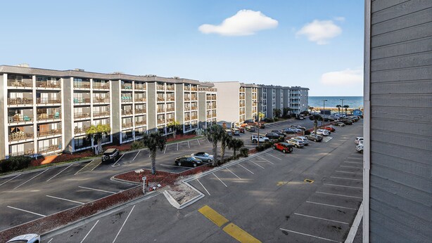 Un parcheggio a più piani adiacente a un hotel sulla spiaggia, con vista diretta sull'oceano.