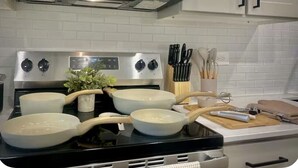 A kitchen with a stove, pots, a microwave, and cabinets. - Workerfriendly, Washerdryer, Wifi,longstaydiscount (Sherman)