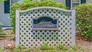A sign with "Mission Place" written on it, mounted on a lattice fence. - Maison Place I (Myrtle Beach)