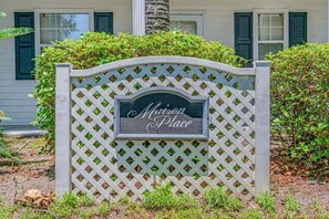 A sign with "Mission Place" written on it, mounted on a lattice fence. - Maison Place I (Myrtle Beach)