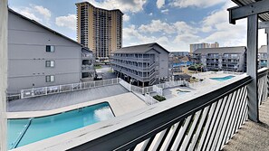 Ein Hotel mit Pool auf dem Dach, mehrere Gebäude im Hintergrund und ein klarer Himmel.