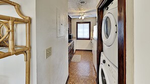 A laundry room with a washing machine, dryer, and a ceiling fan. - Shipwatch Pointe I F217 (Myrtle Beach)