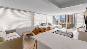 Een modern appartement met een groot bed, een eethoek en een keuken.