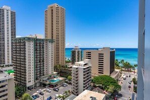 Um hotel imponente com vários andares, uma piscina no terraço e vista para o oceano.