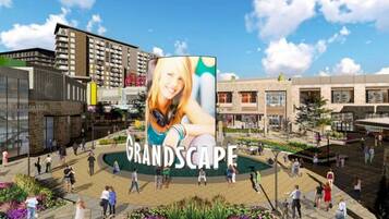 Een openbaar plein met een groot reclamebord waarop 'GRANDSCOPE' staat.