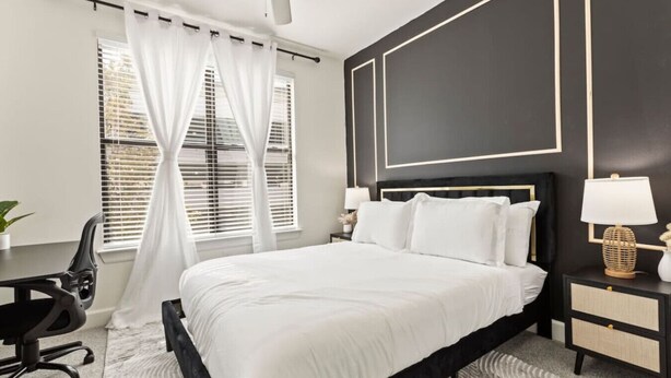 Une chambre à coucher moderne avec un grand lit, un bureau et une chaise.