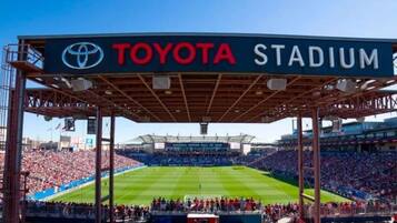 A stadium with a large crowd, a visible Toyota sign, and a green field.