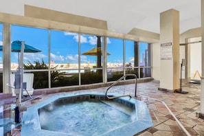 A hot tub with a view of a cityscape through large windows. - Daytona Beach Resort 803 (Daytona Beach)