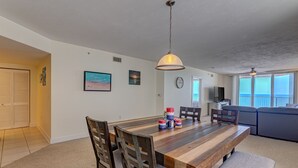 Un comedor amplio con mesa de madera, sillas y una lámpara colgante.
