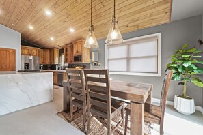 A kitchen with wooden cabinets, a marble island, and pendant lighting. - Spacious Park City Retreat With a Private Hot Tub (Park City)