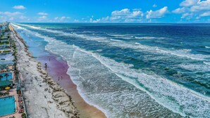 Una playa con piscina y sillas de playa.