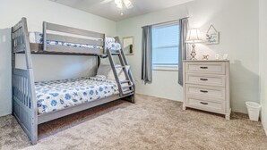 A bunk bed with a ladder, a dresser, a ceiling fan, and a window with curtains. - Twenty-six Twenty-six 202 - Shores Delight (Daytona Beach)