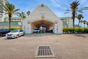A hotel entrance with a prominent DBR sign, a covered parking area, and palm trees. - Daytona Beach Resort 406 (Daytona Beach)