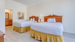 Ett hotellrum med två sängar, var och en med en sänggavel i trä och vitt sänglinne. Det finns en tavla på väggen och en lampa vid varje säng.